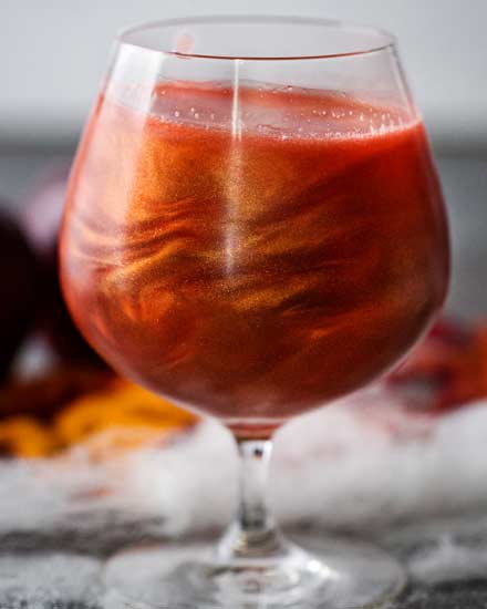 Perfect for Fall and Halloween, this sweet and eerily beautiful cocktail is made with just a handful of ingredients, and tastes every bit as great as it looks! #cocktail #drink #applecider #Halloween #Fall #falldrink #drinks #lusterdust #viniq 