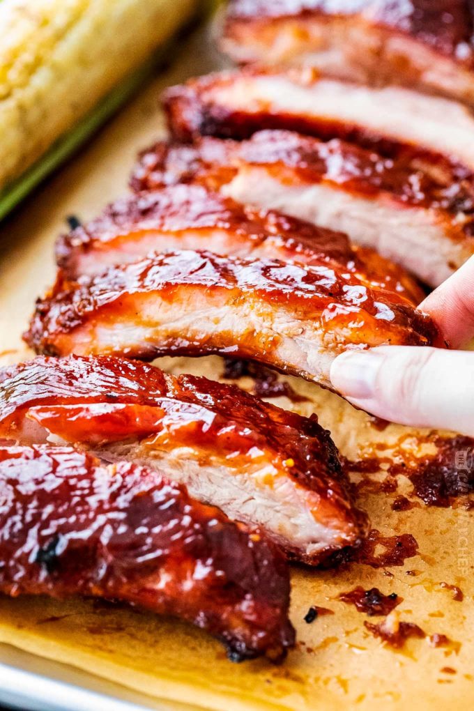 SOSTENIENDO COSTILLAS AHUMADAS CON SALSA BBQ