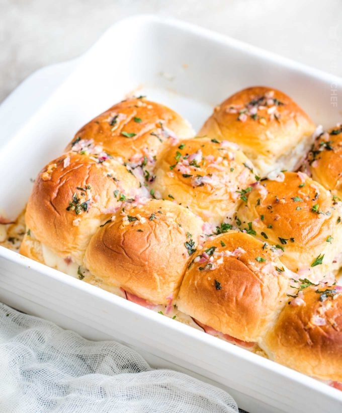 Ham and cheese sliders in baking pan with butter sauce