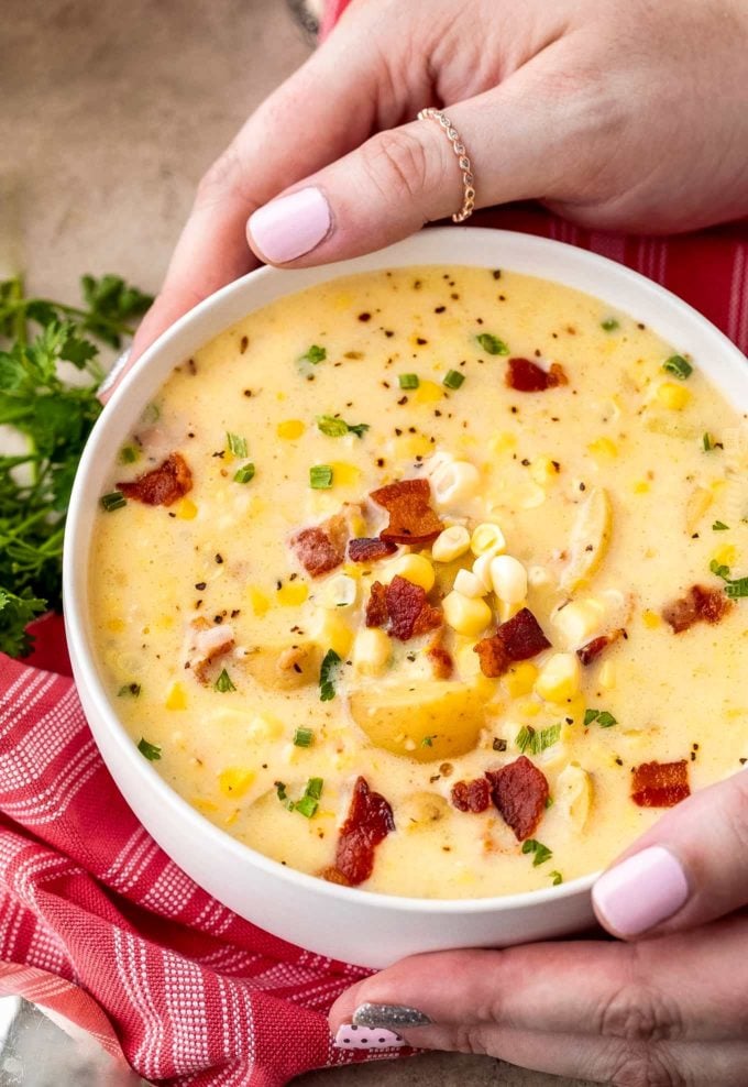 Holding a bowl of creamy corn chowder