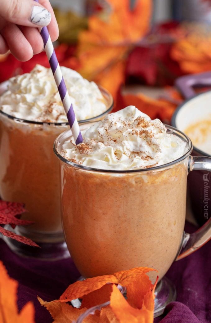 Adding a straw to mug of pumpkin hot chocolate