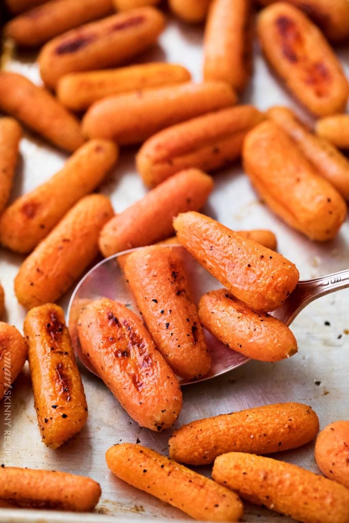 Scoop of roasted carrots on sheet pan