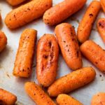 These simple roasted carrots are made easily on a sheet pan, with a simple roasting method that brings out the natural sweetness of the baby carrots.  They're the perfect side dish!  #roasted #carrots #sidedish #holidayrecipe #carrotrecipe #sheetpan #healthy #side #thanksgiving
