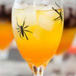 This non-alcoholic Halloween party punch is layered to resemble candy corn, with plastic spiders added for a fun spooky effect! #punch #party #trickortreat #halloween #nonalcoholic #drinkrecipe #mocktail