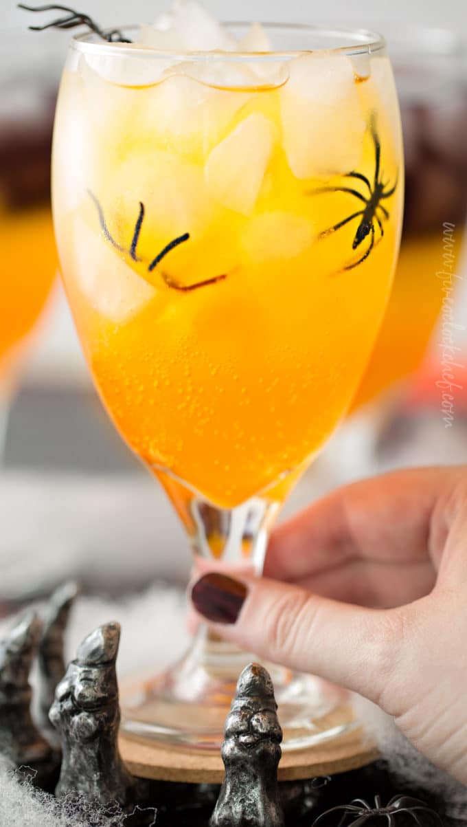 This non-alcoholic Halloween party punch is layered to resemble candy corn, with plastic spiders added for a fun spooky effect! #punch #party #trickortreat #halloween #nonalcoholic #drinkrecipe #mocktail