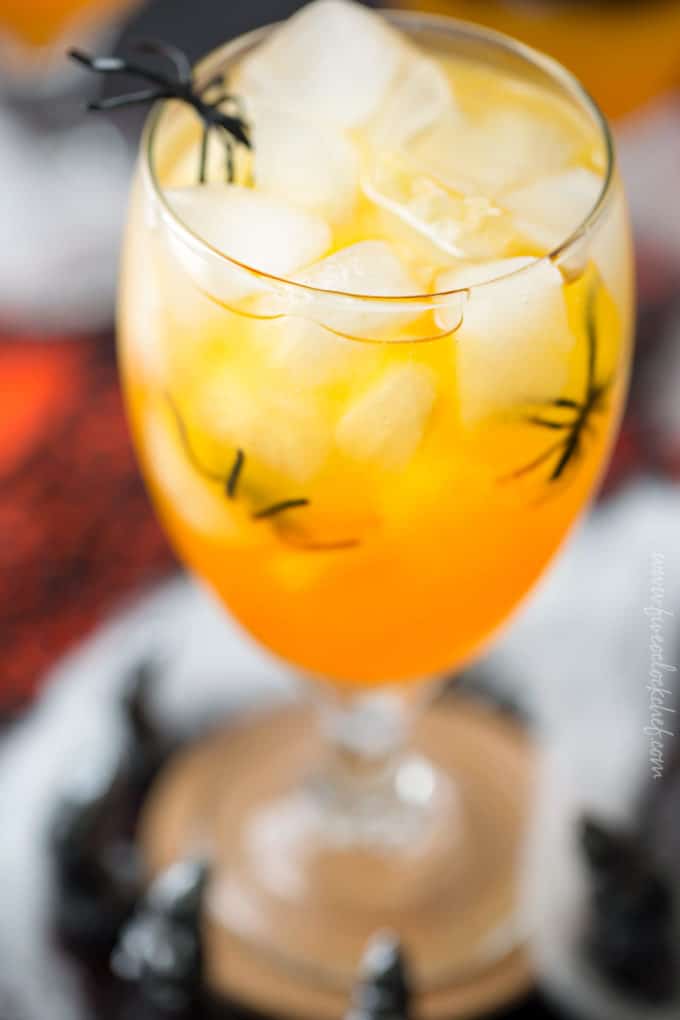 This non-alcoholic Halloween party punch is layered to resemble candy corn, with plastic spiders added for a fun spooky effect! #punch #party #trickortreat #halloween #nonalcoholic #drinkrecipe #mocktail