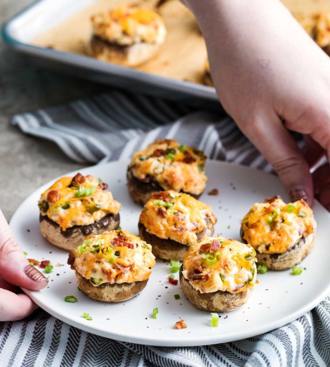 Holding a plate of jalapeno popper stuffed mushrooms