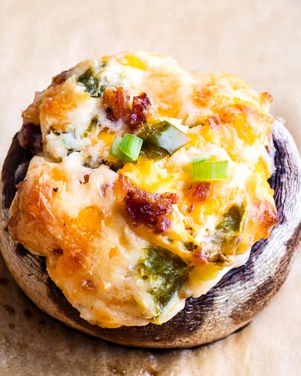 This epic game day food is all the deliciousness of a cheesy jalapeno popper, stuffed into mushrooms!  Spicy, creamy, and super cheesy, this is the appetizer your guests really want! #stuffedmushrooms #mushrooms #jalapeno #jalapenopopper #cheesy #appetizer #gameday #partyfood #easyrecipe