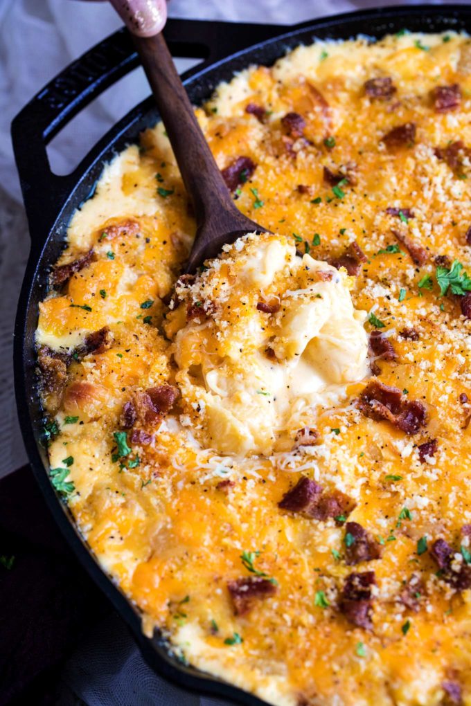 Spoon digging into mac and cheese in skillet