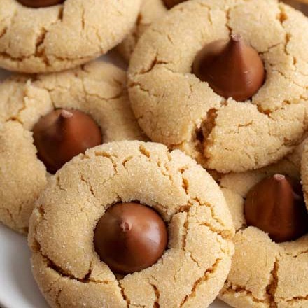 These classic and iconic Peanut Butter Blossoms Cookies are soft and chewy, with a crackly sugary crust and studded with a solid milk chocolate kiss.  Perfect for any holiday, bake sale or cookie exchange! #cookierecipe #cookie #Christmas #baking #peanutbutter #peanutbutterandchocolate #xmas #holidaybaking #holiday