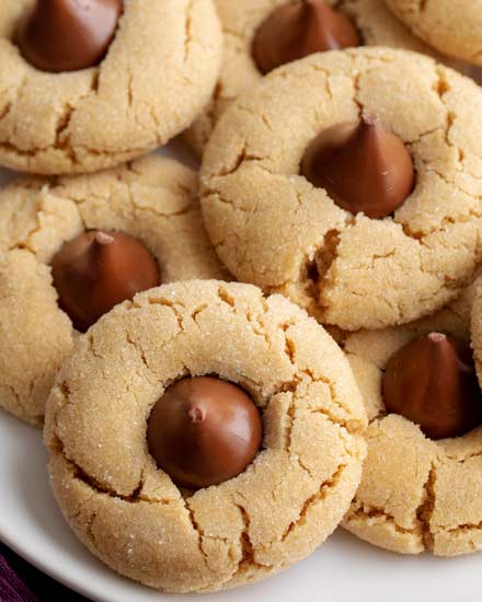 These classic and iconic Peanut Butter Blossoms Cookies are soft and chewy, with a crackly sugary crust and studded with a solid milk chocolate kiss.  Perfect for any holiday, bake sale or cookie exchange! #cookierecipe #cookie #Christmas #baking #peanutbutter #peanutbutterandchocolate #xmas #holidaybaking #holiday