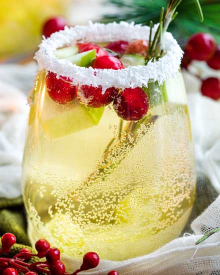 Sweet and festive, this white sangria recipe is full of Christmas cheer!  Easy to make for holiday entertaining, and can be made non-alcoholic as well! #sangria #white #christmas #holiday #winter #alcohol #drink #party #whitewine