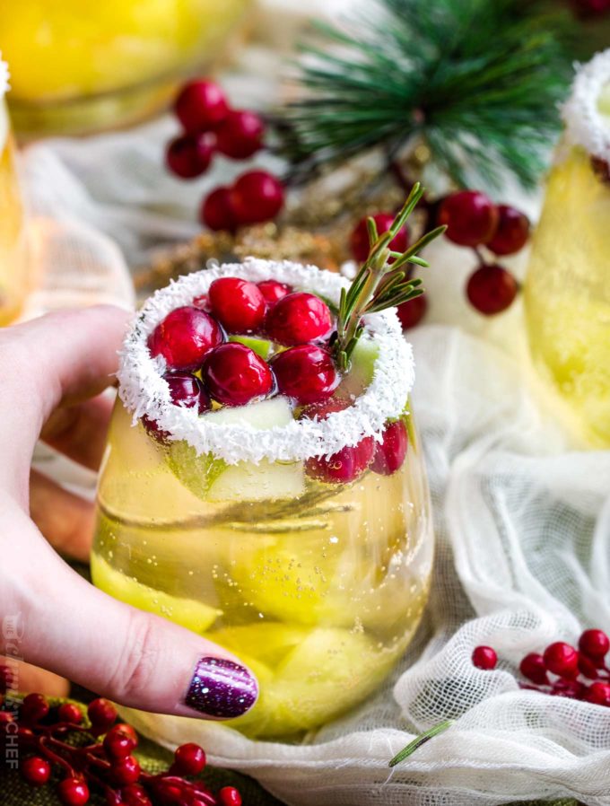 Holding a glass of christmas sangria