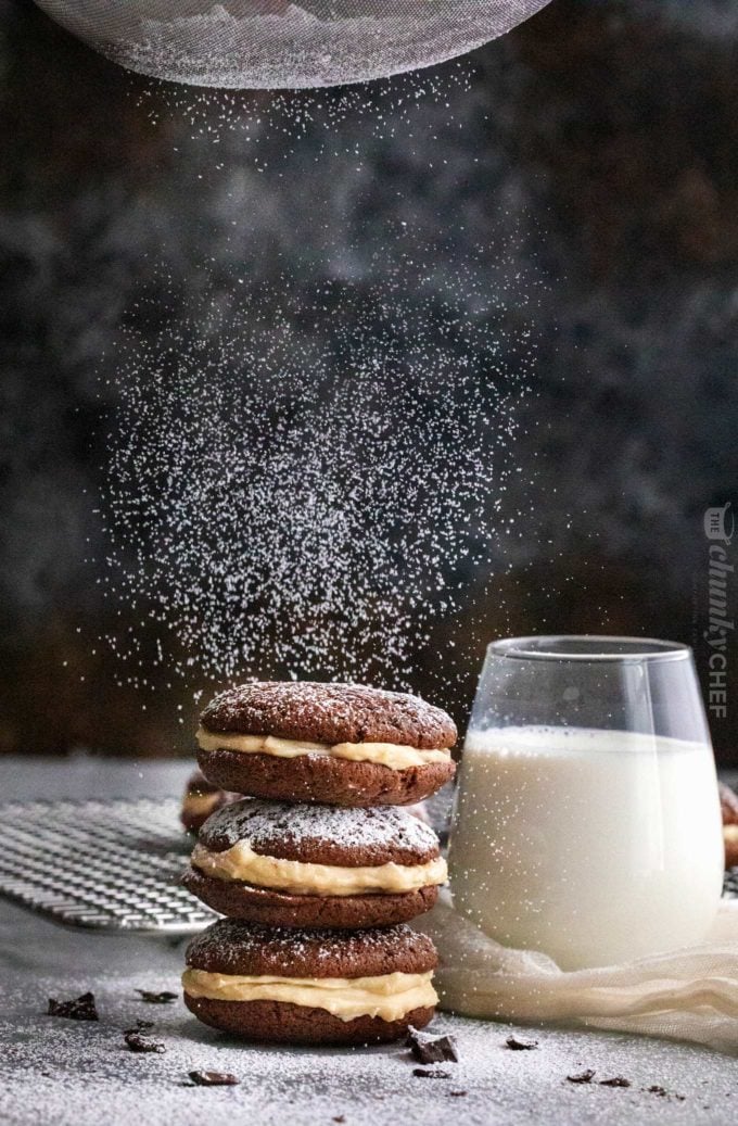 Dusting tiramisu whoopie pies with powdered sugar