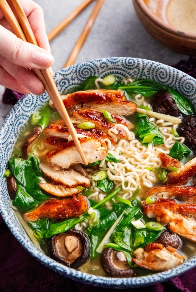 Using chopsticks to eat chicken ramen