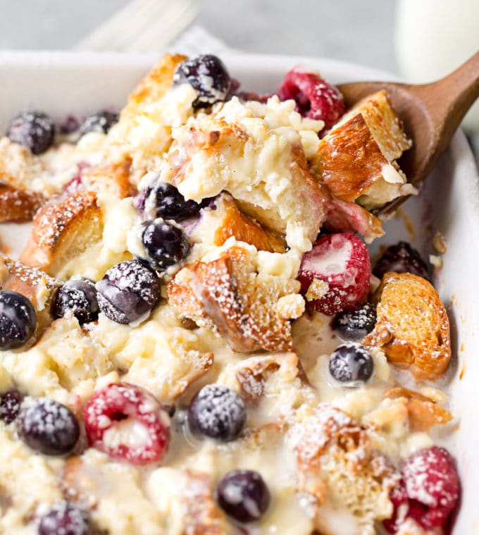 Scooping out a serving of croissant breakfast bake with berries