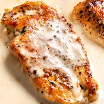 Tender chicken breasts smothered in a rich garlic cream sauce, all made in the same pan, and ready in less than 30 minutes! #easyrecipe #weeknightdinner #dinnerrecipe #chicken #garlic #creamy #onepan #onepot #skilletmeal