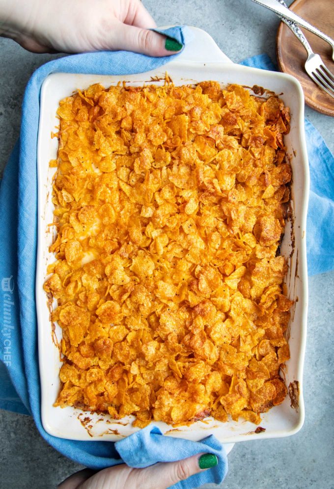 Serving a dish full of cheesy potato casserole