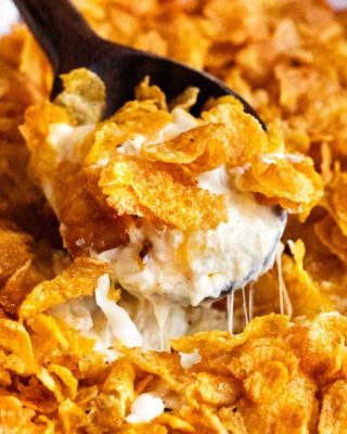 Funeral potatoes, aka Cheesy Potato Casserole, the hot side dish that EVERYONE loves. Perfect for any dinner, holiday or potluck! Rich, cheesy and creamy hashbrown potatoes topped with buttery cornflakes and baked until golden and crispy! #potatoes #cheesy #potatocasserole #funeralpotatoes #partypotatoes #sidedish #potluck #holiday #hashbrown #baked #casserole