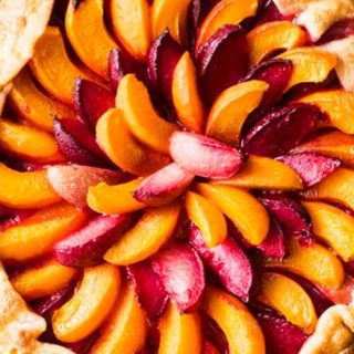 Every bit as mouthwatering as fruit pie, this stone fruit galette is a fuss-free way to enjoy the freshest seasonal fruits! Tender pie crust envelopes a mixture of plums, apricots and sugar, and is perfect topped with a scoop of frosty vanilla ice cream! #pie #galette #dessert #easyrecipe #fruit #plum #piecrust