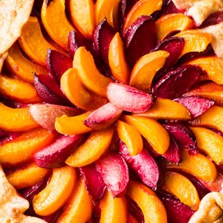 Every bit as mouthwatering as fruit pie, this stone fruit galette is a fuss-free way to enjoy the freshest seasonal fruits!  Tender pie crust envelopes a mixture of plums, apricots and sugar, and is perfect topped with a scoop of frosty vanilla ice cream! #pie #galette #dessert #easyrecipe #fruit #plum #piecrust