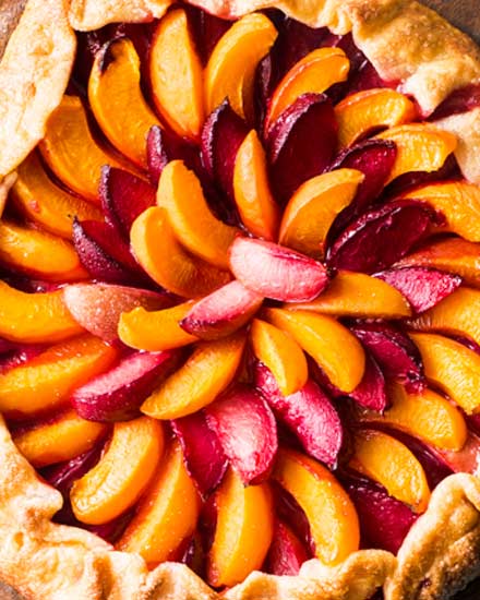 Every bit as mouthwatering as fruit pie, this stone fruit galette is a fuss-free way to enjoy the freshest seasonal fruits!  Tender pie crust envelopes a mixture of plums, apricots and sugar, and is perfect topped with a scoop of frosty vanilla ice cream! #pie #galette #dessert #easyrecipe #fruit #plum #piecrust