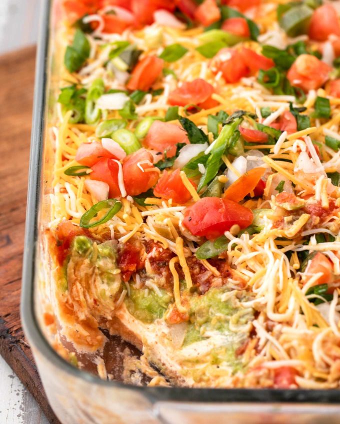 Always a huge crowd-pleaser, this 7 layer dip is literally layer upon layer of bold, mouthwatering flavors!  This appetizer is perfect for any game day party, or holiday gathering! #appetizer #party #gameday #layerdip #7layerdip #beandip #mexican #fiesta
