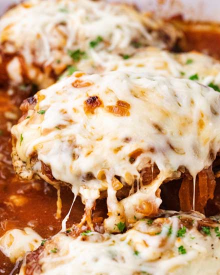 Juicy chicken breasts absolutely smothered in saucy caramelized onions and loads of gooey cheese!  French onion baked chicken is easy to prep ahead too! #bakedchicken #frenchonion #chicken #comfortfood #dinnerrecipe #easyrecipe 