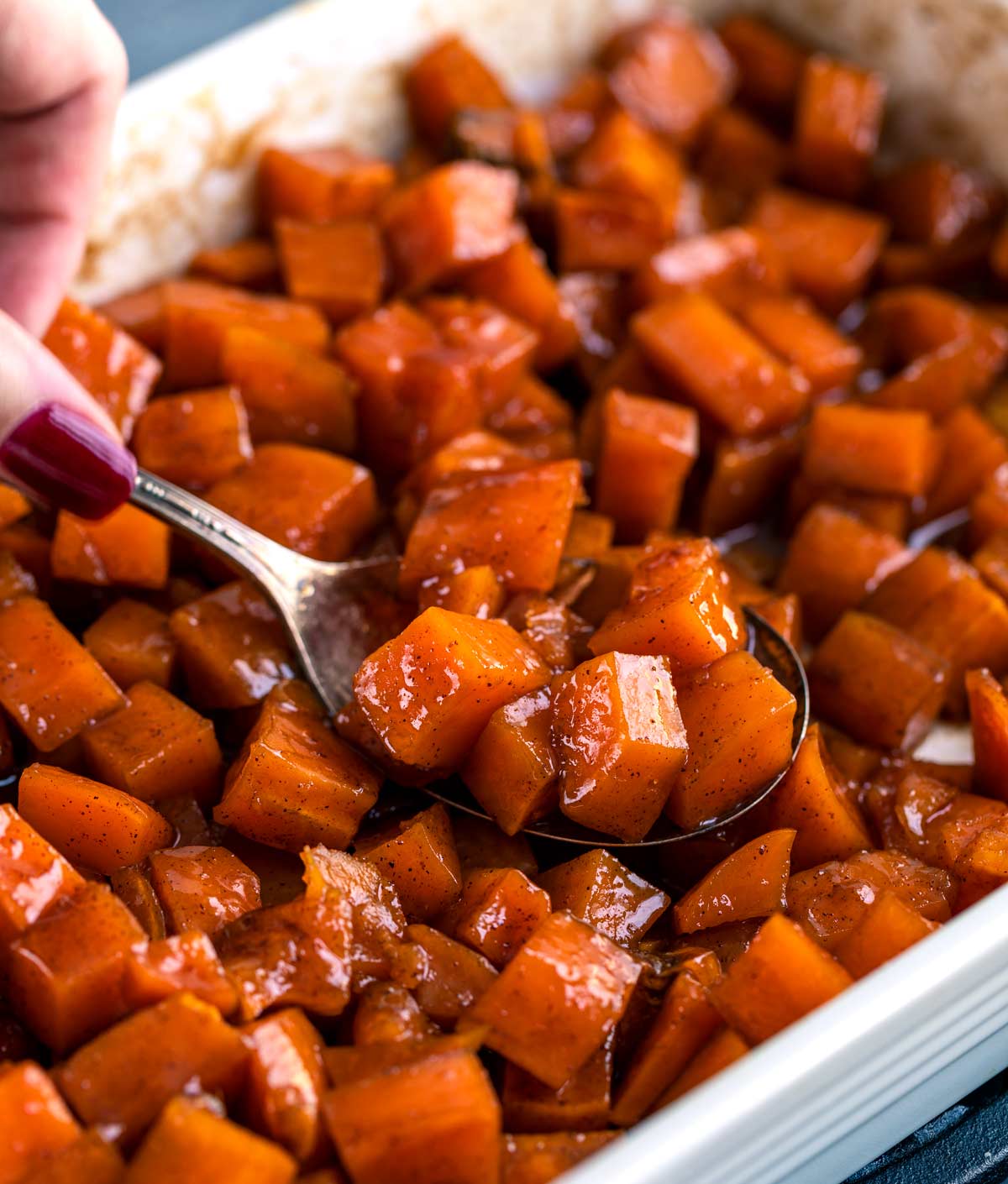 Candied yams in baking dish with spoon
