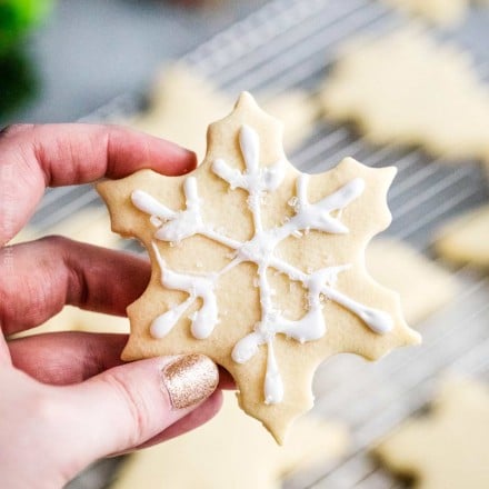 holding decorated sugar cookie snowflake