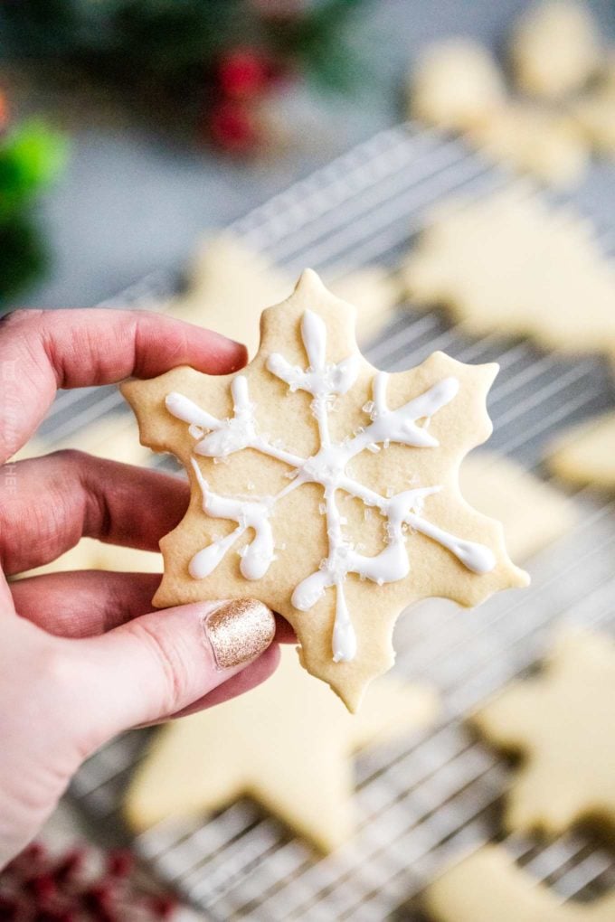 holding decorated sugar cookie snowflake