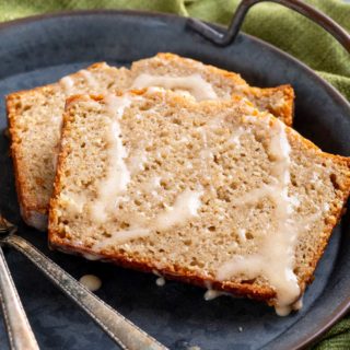 Quick bread recipe made with real eggnog, warming spices and rum, topped off with a sweet cinnamon rum glaze! This holiday eggnog bread is perfect as a dessert, or holiday breakfast. Makes one large loaf, or 3 smaller loaves. #eggnog #bread #quickbread #holidaybaking #christmas #bakingrecipe #dessert #breakfast