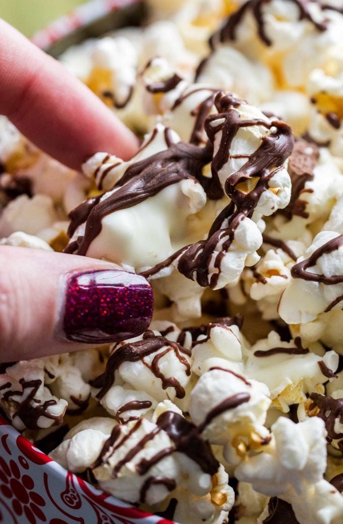 Holding a piece of chocolate covered popcorn