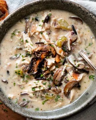 Hearty and ultra comforting, this Chicken and Wild Rice Soup is full of tender chicken and veggies, a creamy broth, nutty wild rice, and topped with more golden brown mushrooms! Stovetop, Slow Cooker and Instant Pot directions! #soup #chicken #wildrice #mushrooms #souprecipe #instantpot #slowcooker #crockpot #stovetop #dinner