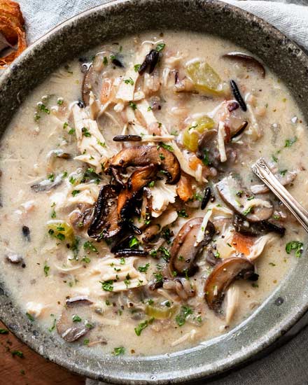 Hearty and ultra comforting, this Chicken and Wild Rice Soup is full of tender chicken and veggies, a creamy broth, nutty wild rice, and topped with more golden brown mushrooms!  Stovetop, Slow Cooker and Instant Pot directions! #soup #chicken #wildrice #mushrooms #souprecipe #instantpot #slowcooker #crockpot #stovetop #dinner