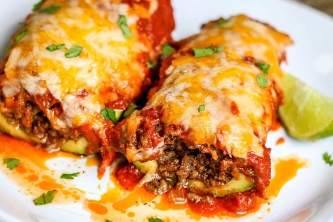 Enchilada zucchini boats are a great family dinner!  Packed with protein and flavor, plus low in carbs, these enchiladas are the perfect healthier dinner recipe! #enchilada #zucchini #stuffed #zucchiniboats #healthyrecipe #easyrecipe #weeknight 