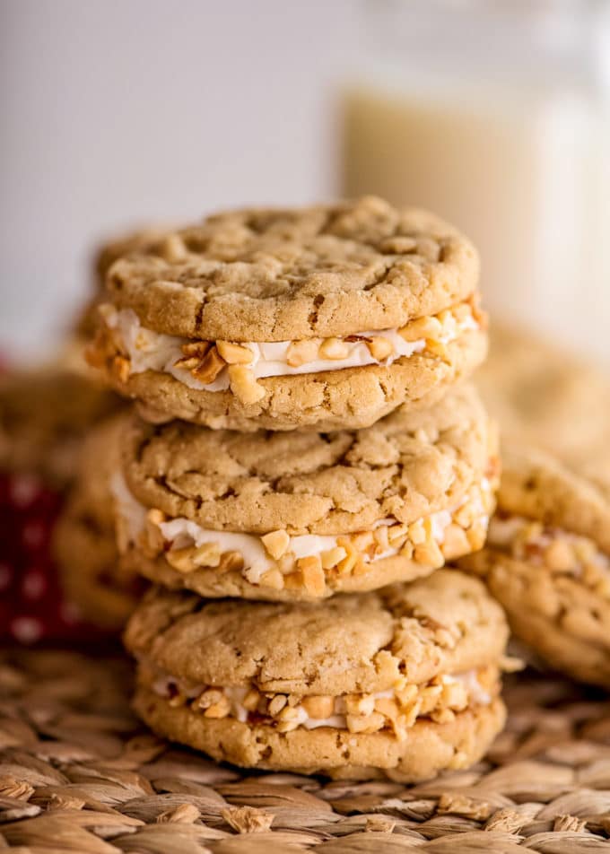 Chewy peanut butter cookies sandwiched together with rich buttercream, and rolled in crushed peanuts!  It's a peanut butter lover's dream dessert! #peanutbutter #cookies #dessert #easyrecipe #baking #chewy #oatmeal #sandwich #homemade