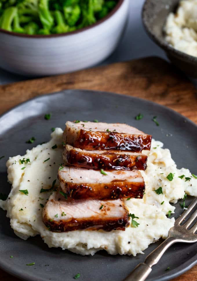 Sliced baked pork chops over mashed potatoes