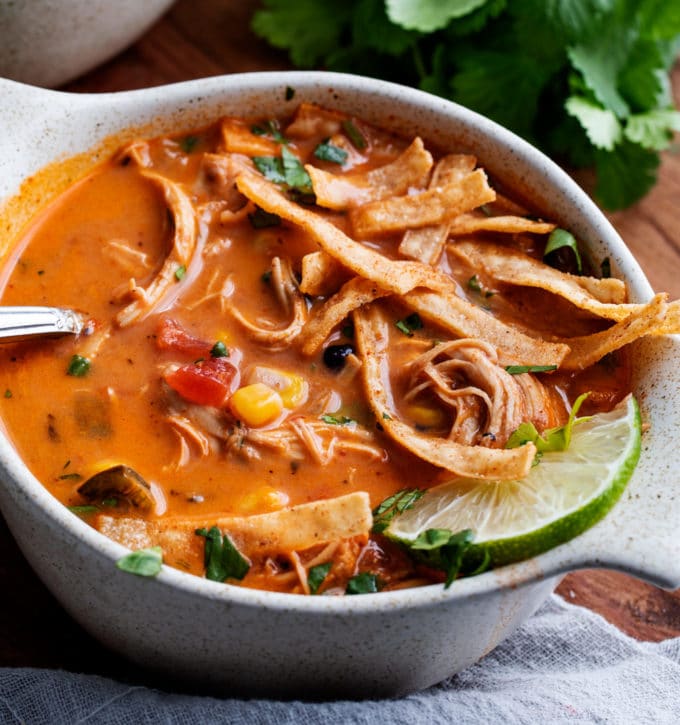 White bowl of tortilla soup with garnishes