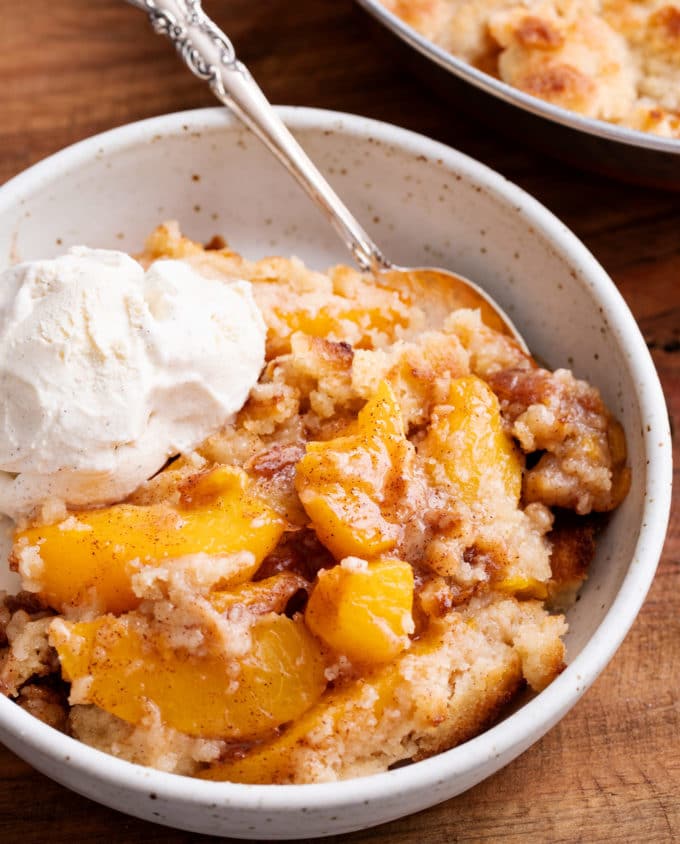 Cobbler in white bowl with vanilla ice cream