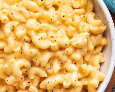 Overhead view of cheesy macaroni in white bowl