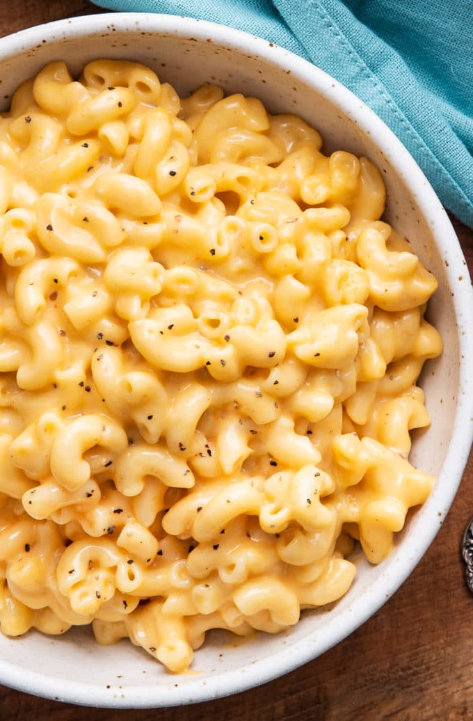 Overhead view of cheesy macaroni in white bowl