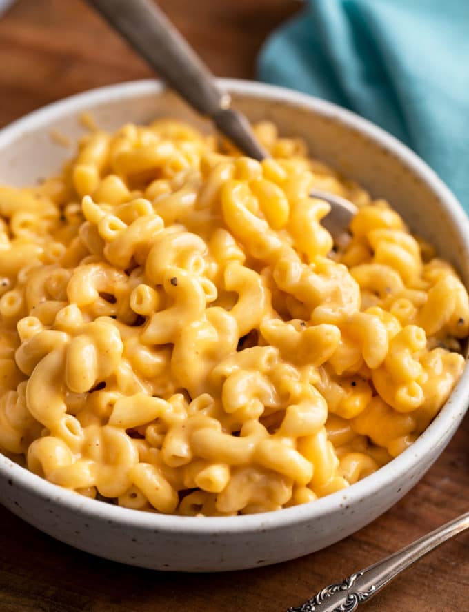 White bowl of mac and cheese with fork