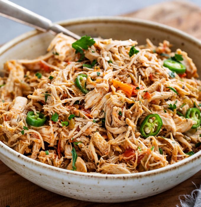 Tender shredded chicken, smothered in the most mouthwatering Mexican sauce made from salsa, green chiles, tomatoes and plenty of bold spices!  Perfect pantry meal, and can be used for so many things (tacos, enchiladas, etc). #chicken #mexican #salsa #shredded #instantpot #pressurecooker #slowcooker #crockpot #cincodemayo #taconight