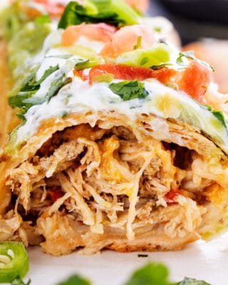 Crispy baked chimichangas stuffed with juicy Mexican spiced chicken and plenty of gooey cheese! Perfect easy family dinner that everyone will love. #chimichangas #chicken #mexican #stuffed #cheese #burrito #baked #crispy #easyrecipe