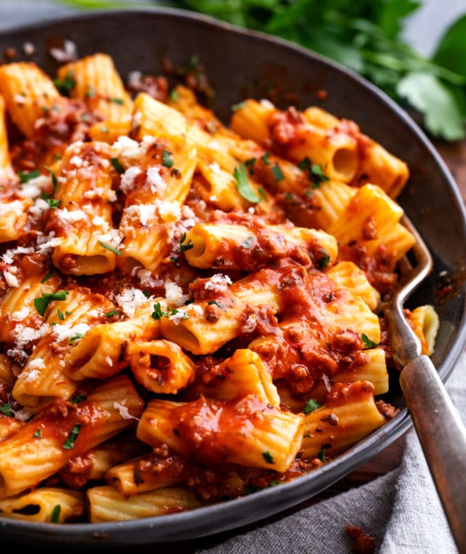 black bowl of pasta with meat sauce