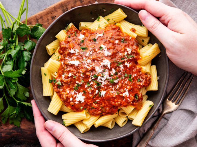 Bolognese sauce on pasta in black bowl