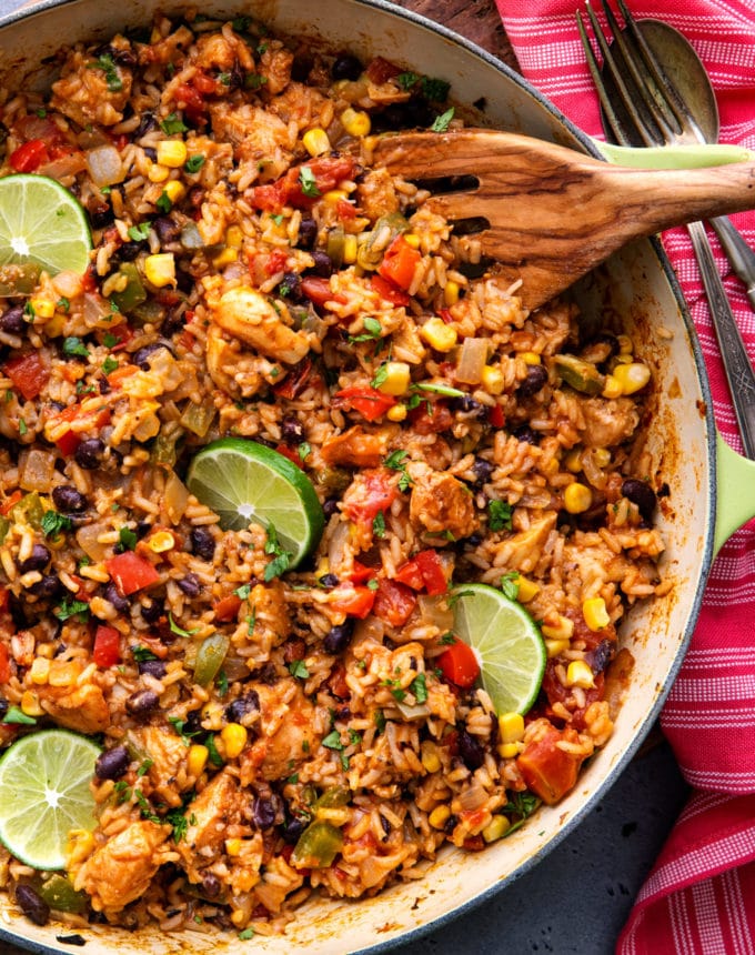 Pan full of mexican chicken and rice with wooden spoon