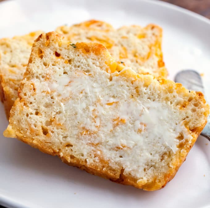 Beer bread with butter on white plate with butter knife