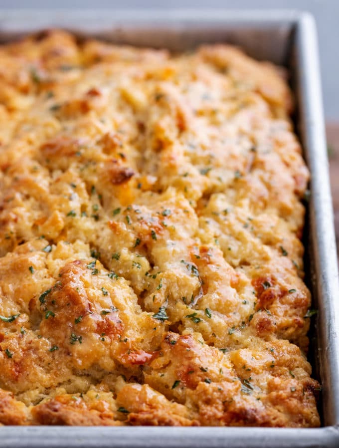 Buttery top of garlic cheddar beer bread in baking pan